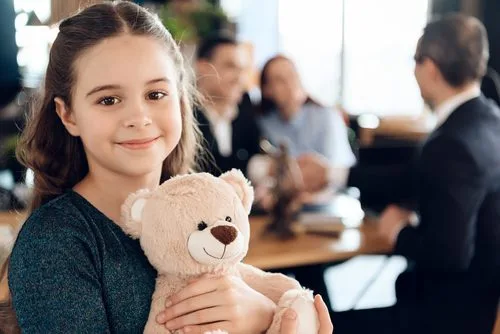 Child holding teddy bear during mediation